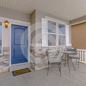 Clear Square Exterior of a home with blue wooden front door and reflective glass windows