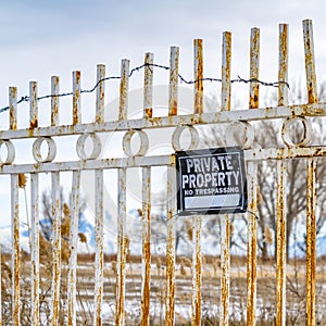 Clear Square Private Property No Trespassing sign on a rusty gate with chain and padlock