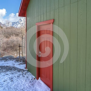 Clear Square Storage shed against trees and snow capped mountain under cloudy blue sky