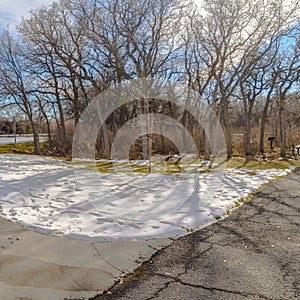 Clear Square Table and benches at a snowy picnic area near a lake on a sunny winter day