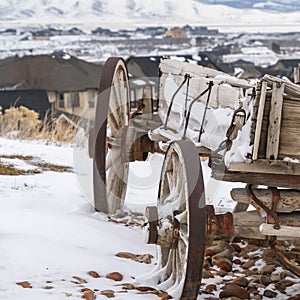 Clear Square Weathered wooden wagon with chains and rusty wheel viewed in winter