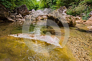 Clear transparent water in a mountain river and stones in the forest