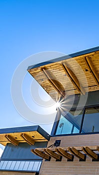 Clear Vertical Exterior of a building with red brick wall and flat roof against vivid blue sky