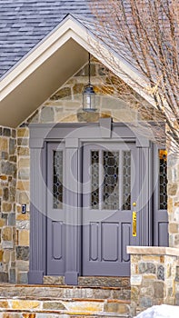 Clear Vertical Facade of a home with a beautiful stone wall and gray front door