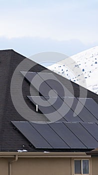 Clear Vertical Solar panels installed on the dark roof of a home with snow in winter