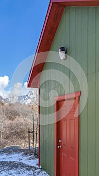 Clear Vertical Storage shed against trees and snow capped mountain under cloudy blue sky