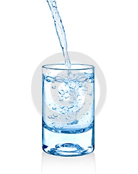 Clear water being poured into a glass cup isolated photo