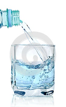 Clear water being poured into a glass cup isolated