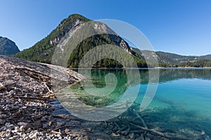 Clear water of lake Braies and mountain in Dolomites