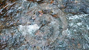 Clear water of natural stream with colorful falling leaves from Ryuzu waterfalls flow on the gravels floor