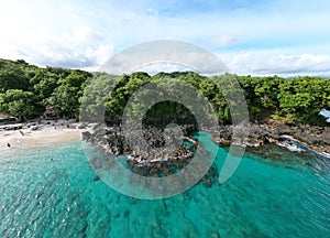 the clear water is next to a sandy beach and forest