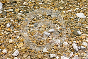 through clear water, small colored stones are visible photo