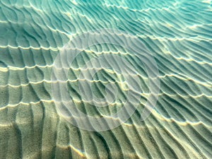 Clear water. underwater background with sandy sea bottom. Beautiful texture of the sea and ocean water