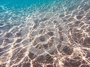 Clear water. underwater background with sandy sea bottom. Beautiful texture of the sea and ocean water