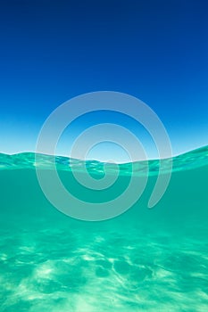 Clear waterline caribbean sea underwater and over with blue sky