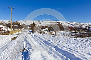 Cleared of snow secondary road from a countryside village