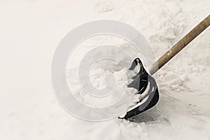 Clearing the road from white snow with a shovel