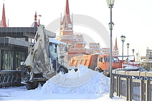 Clearing snow from the road with bulldozer and truck in the city