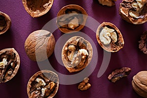 Cleaved and whole walnuts on a light wooden background.