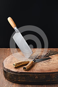 Cleaver, fork and knife on wooden blockhead
