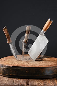 Cleaver and two meat knives sticking out of wooden blockhead