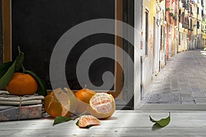 Clementines and leaves on window sill, alley