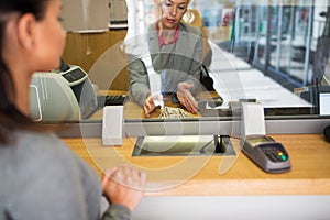 Clerk with cash money and customer at bank office