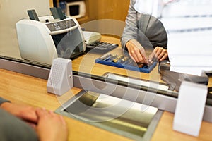 Clerk counting cash money at bank office