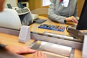 Clerk counting cash money at bank office