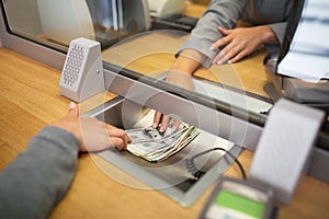 Clerk giving cash money to customer at bank office