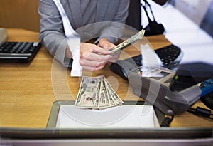 Clerk giving cash money to customer at bank office