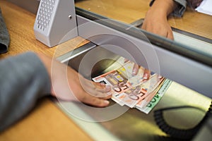 Clerk giving cash money to customer at bank office