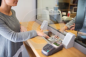 Clerk giving cash money to customer at bank office