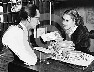 Clerk with woman mailing letter photo