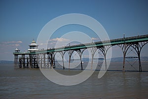 Clevedon pier putside of Bristol in South West England under the scorching sun on a clear summers day as the river servern lazily