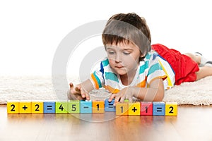 Clever boy with blocks on the carpet