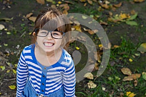 Clever child with eyeglasses smiling and looking at camera. Young pupil ready for study at school.