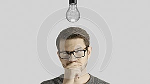 Clever creative man think gets an idea, which lights up a symbolic lamp over his head on white background