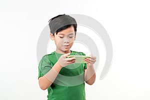 Clever kid is playing with green smart cell phone isolated on white background