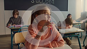 Clever kid raising hand during lesson. Cute student answering for question