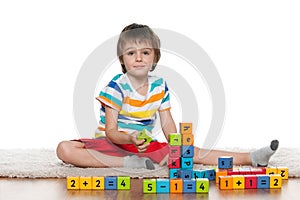 Clever little boy with blocks on the floor