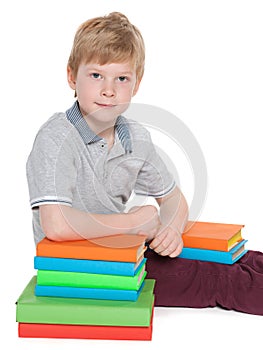 Clever little boy with a pile of books