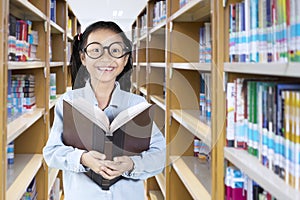 Clever little girl holding a textbook