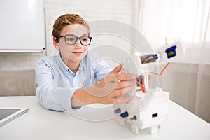 Clever schoolboy constructing robot at stem educational class