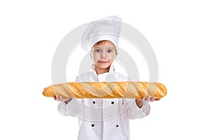 Clever serious chef girl in a cap cook uniform, holding the long loaf of bread horizontally. Looking at the camera