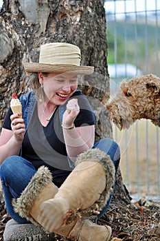 Clever sneaky pet dog sneaking up to pinch ice cream that pretty young girl eating