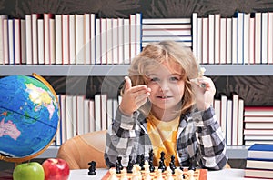 Clever thinking child. Kid playing chess. Clever child thinking about chess. Kids early development.