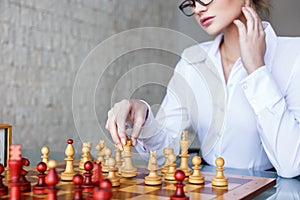 Clever woman moving with queen on chessboard