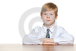 Clever young boy is sitting at the desk