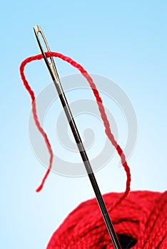 Clew and needle with red thread